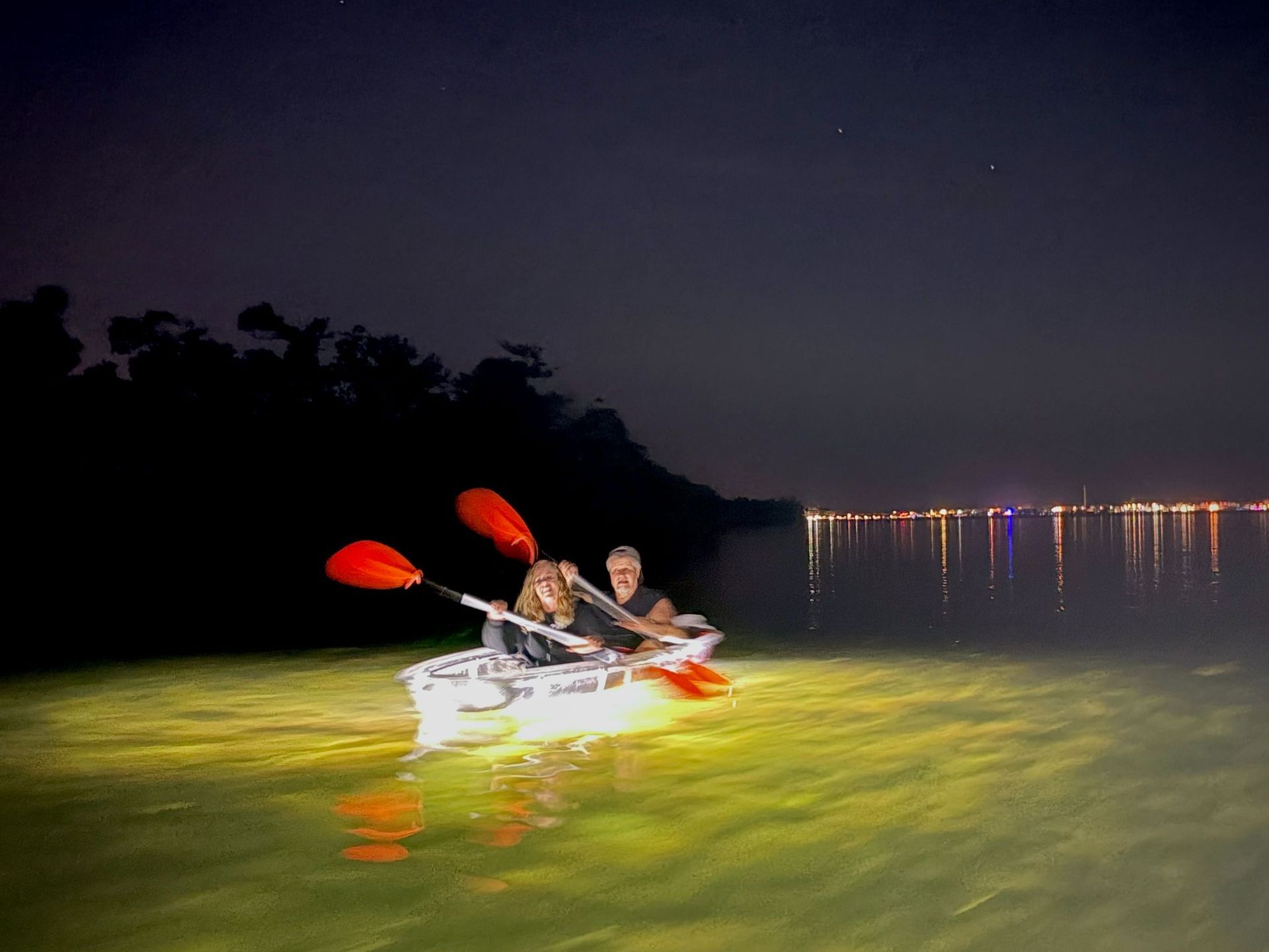 Grandfather and grandson driving pontoon boat. 