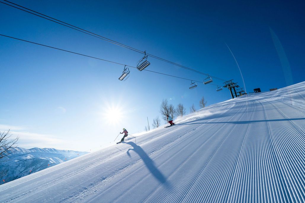 People skiing down a mountain slope.