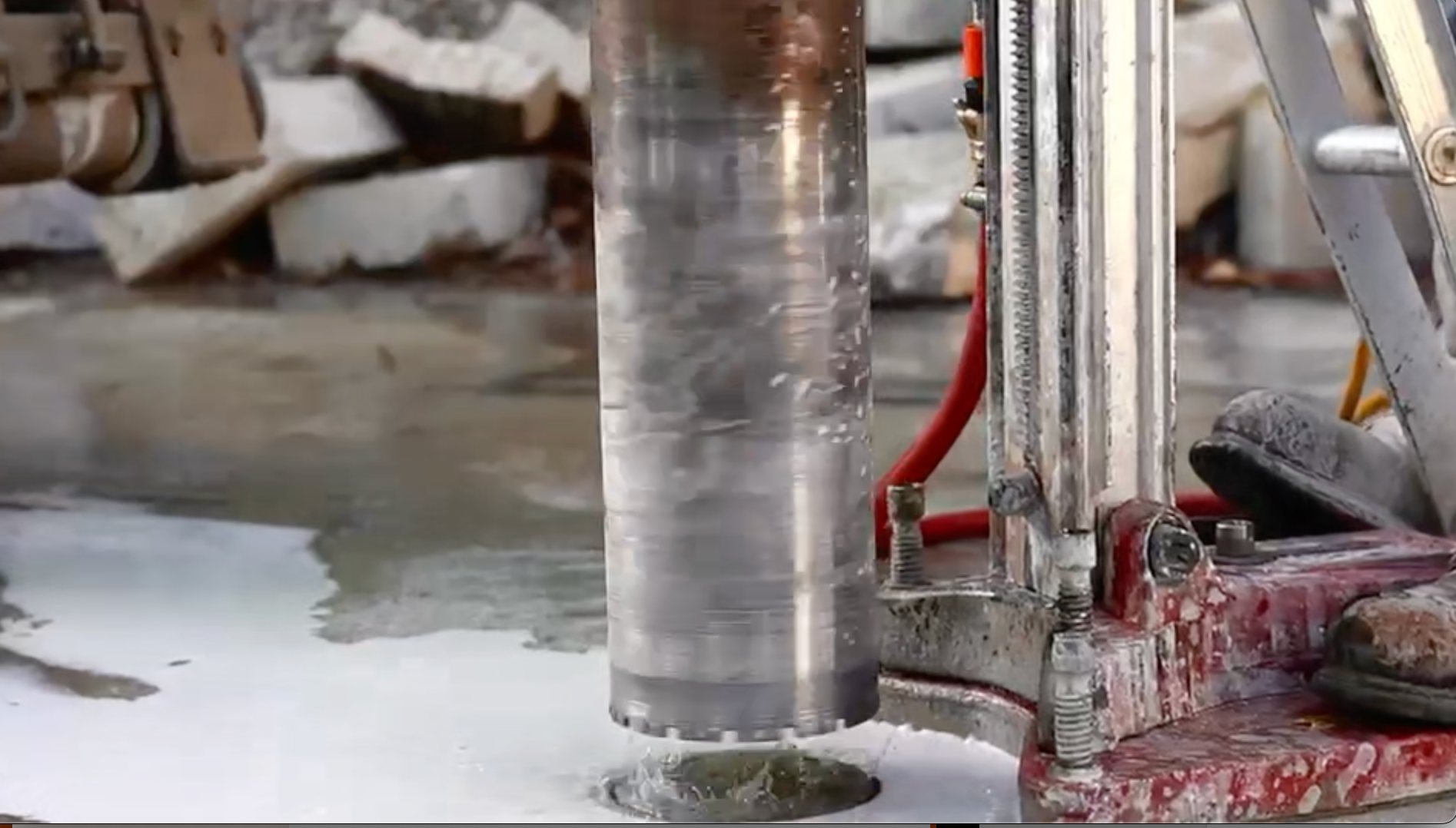 A man is drilling a hole in the ground with a drill.