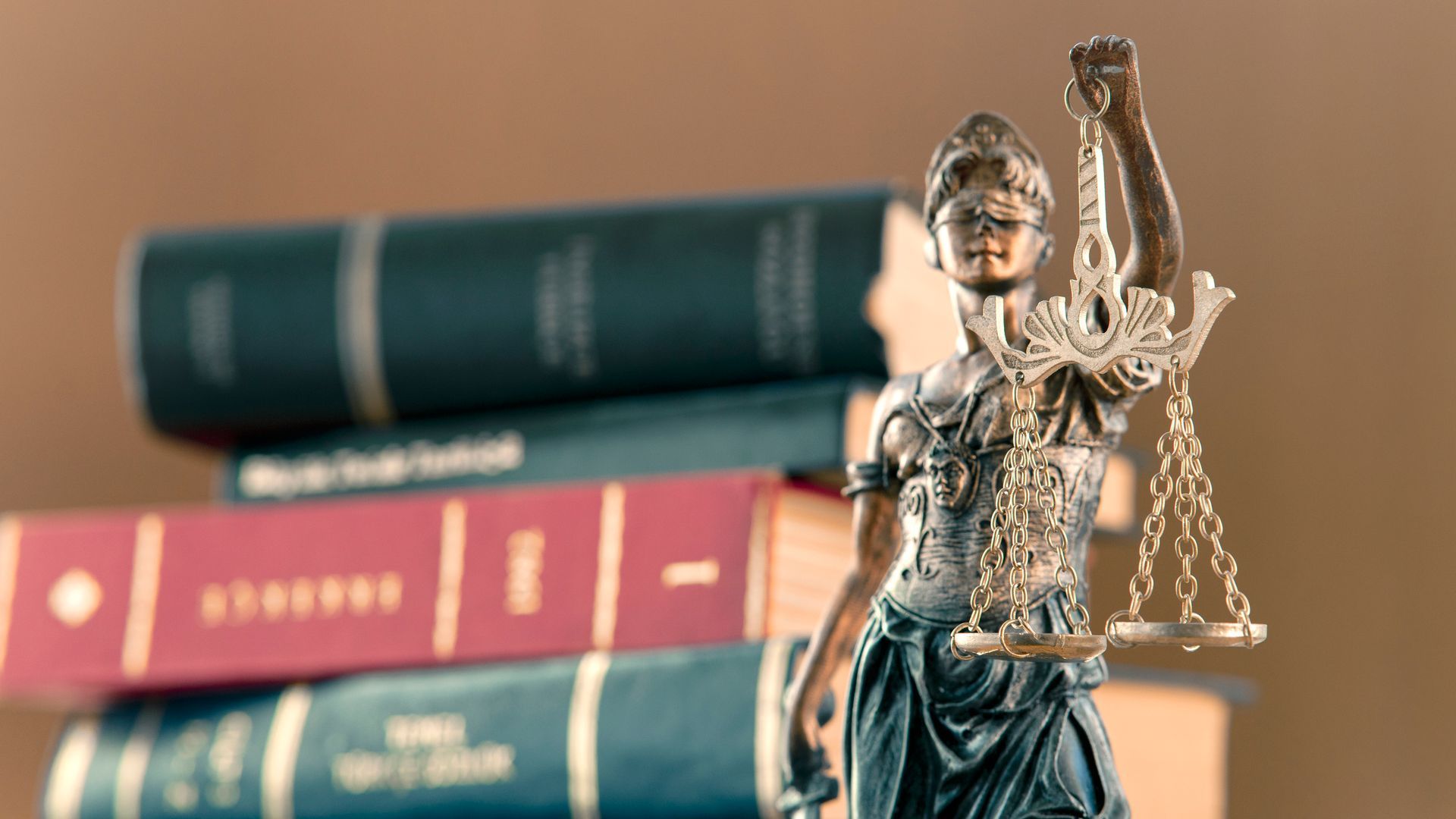 una statua di giustizia in piedi davanti a una pila di libri