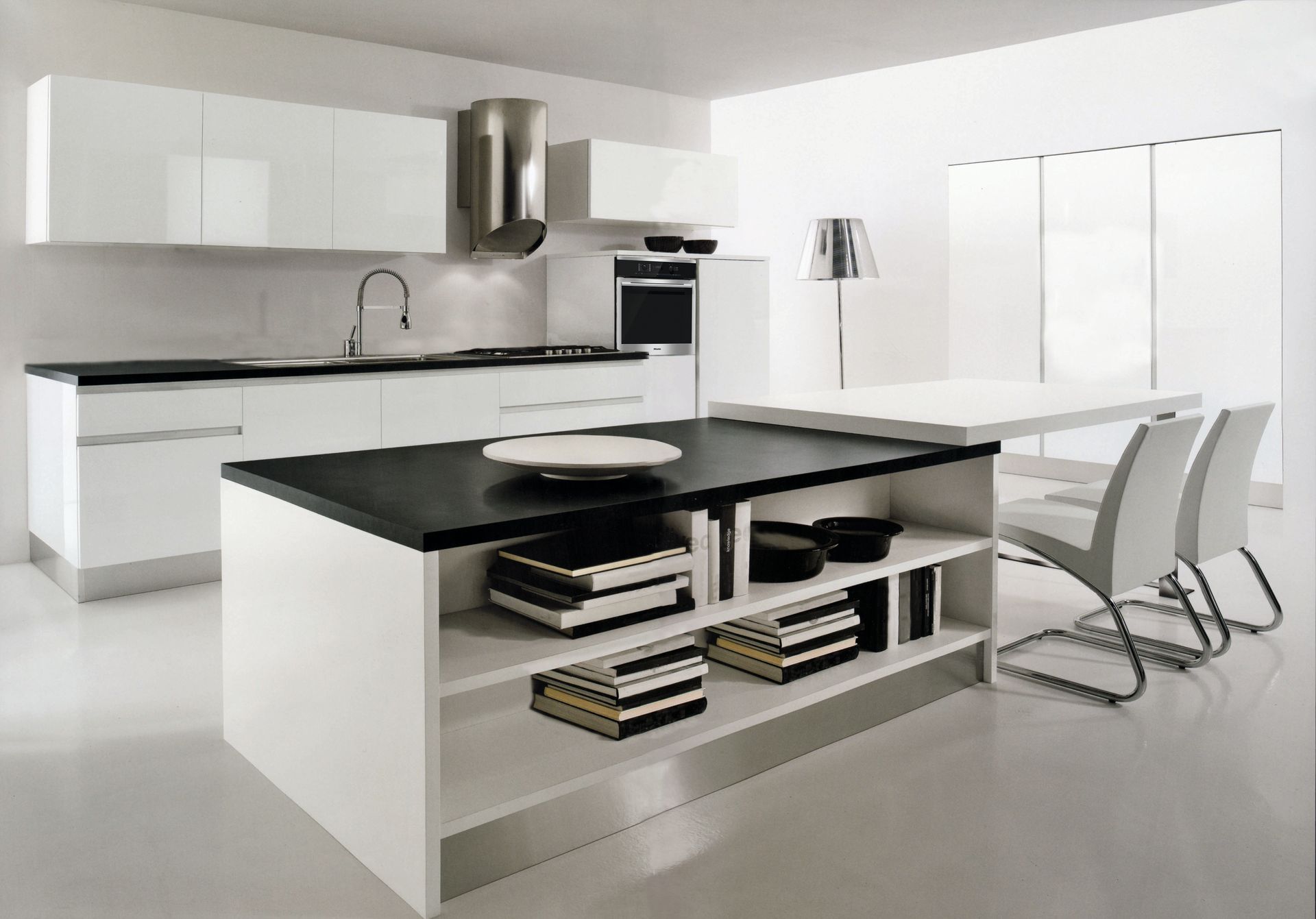 Una cucina con mobili bianchi e un piano di lavoro nero