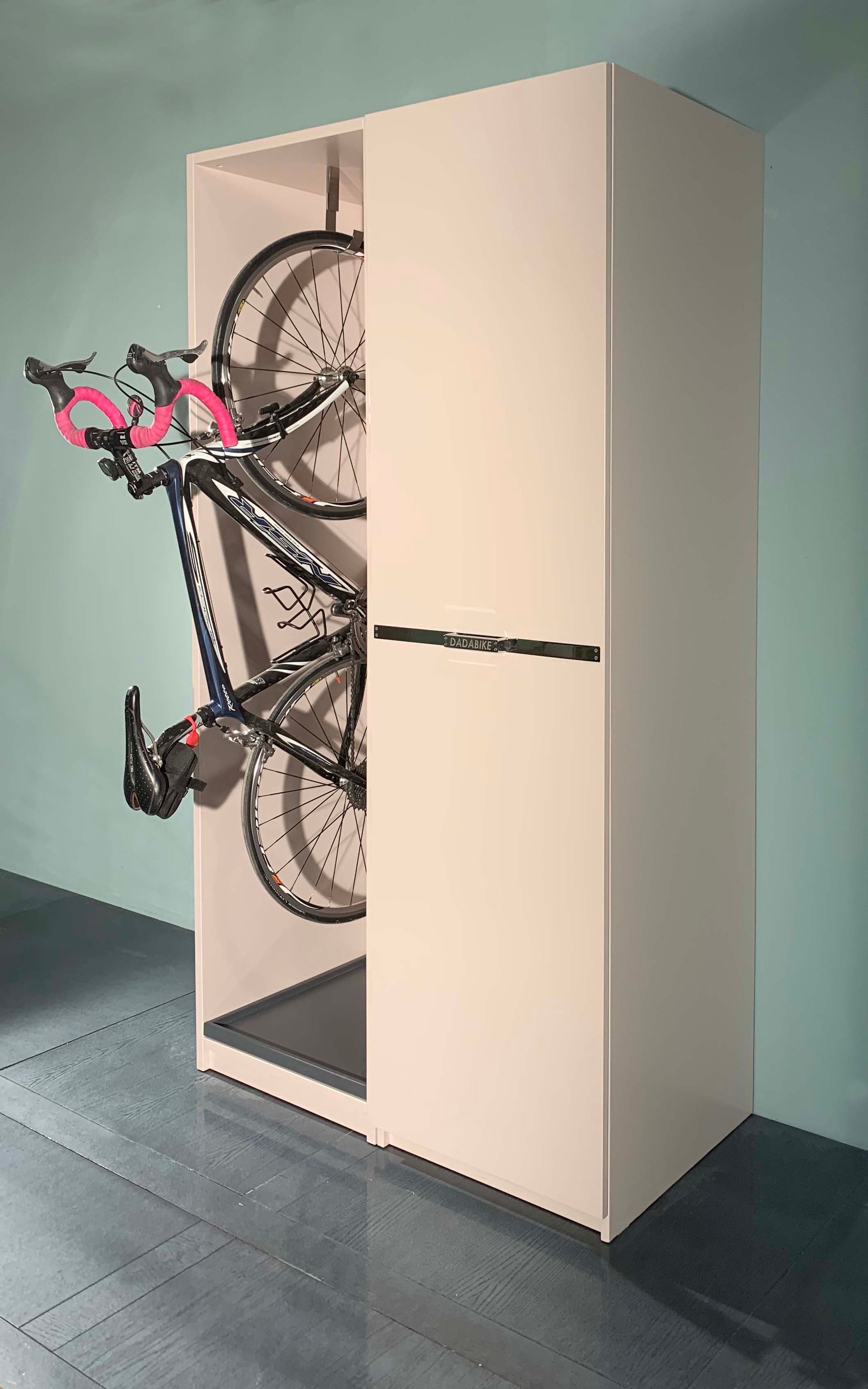 Una bicicletta è appesa al lato di un mobile bianco.