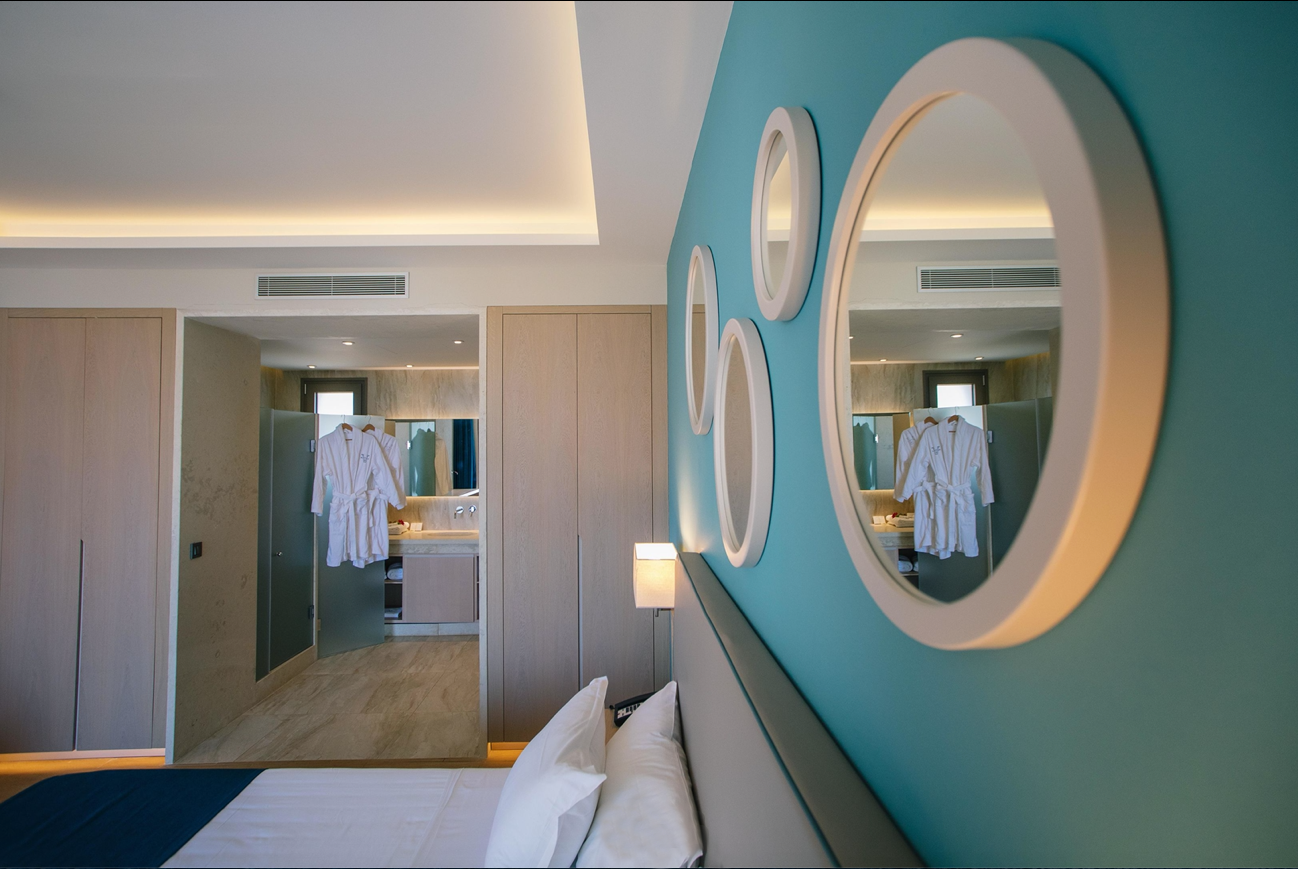 Una stanza d'albergo con un letto e specchi alle pareti.