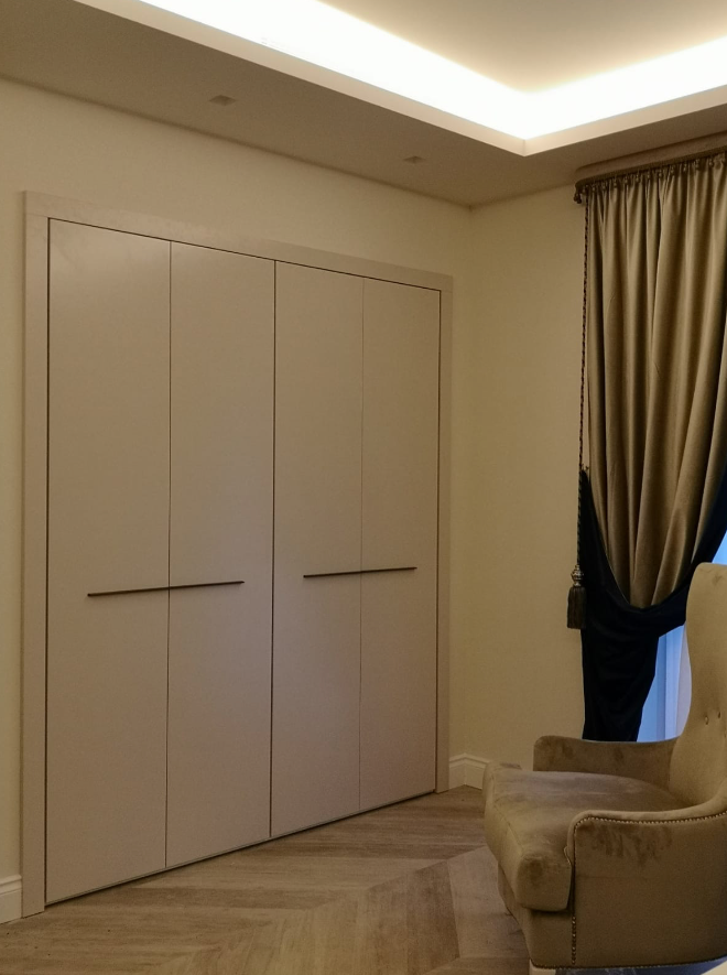 Un soggiorno con una sedia e un grande armadio