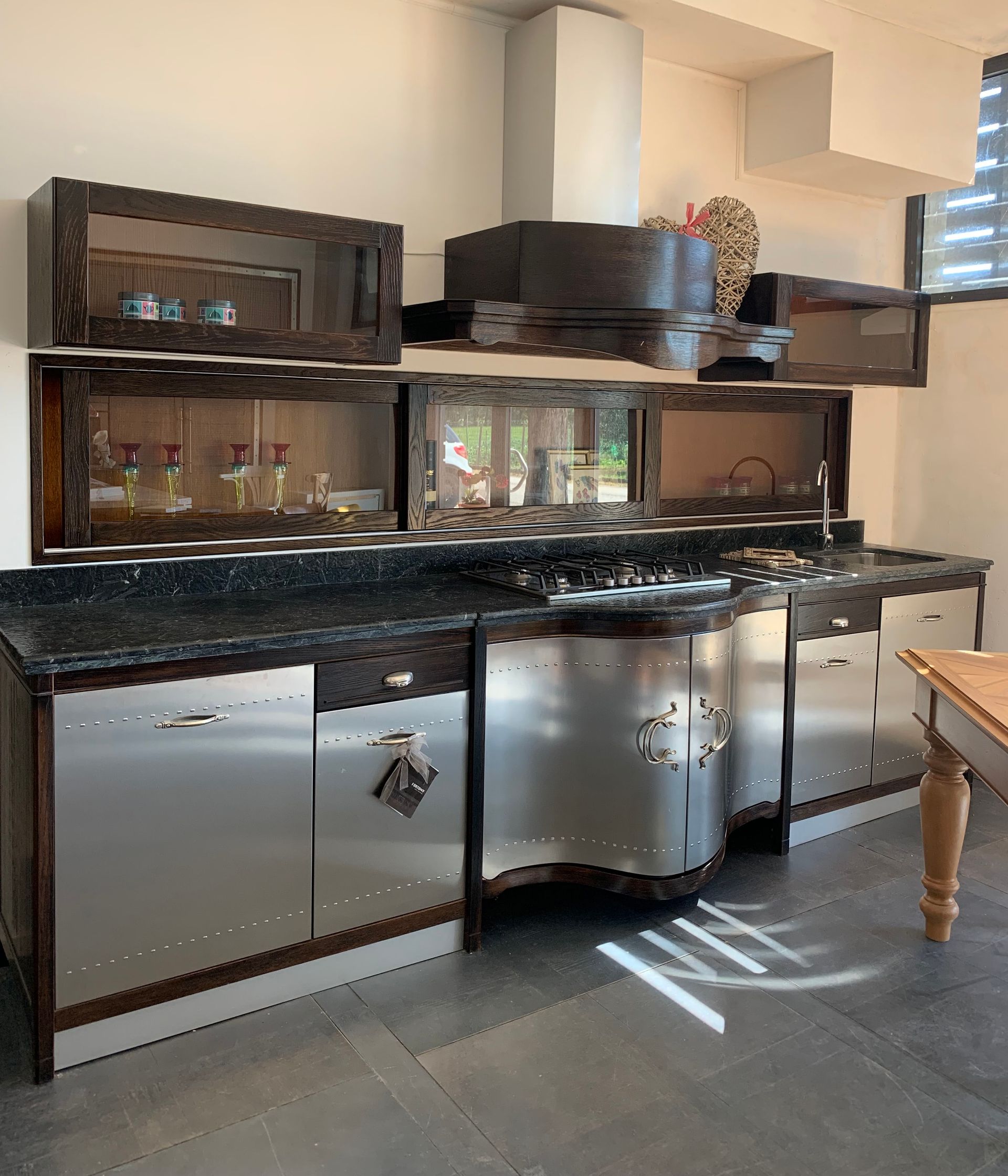 Una cucina con elettrodomestici in acciaio inossidabile e ripiani neri