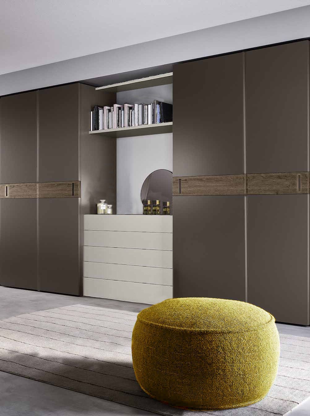 Un pouf giallo è posizionato davanti a un grande armadio
