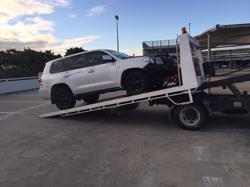Towing White Car — Reliable Tilt Tray Services in Paget QLD