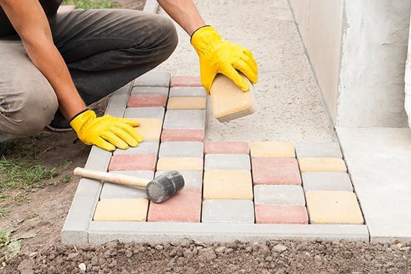 Construction Worker Laying Paving Slab Tiles — Haverstraw, NY — K & P Asphalt Inc