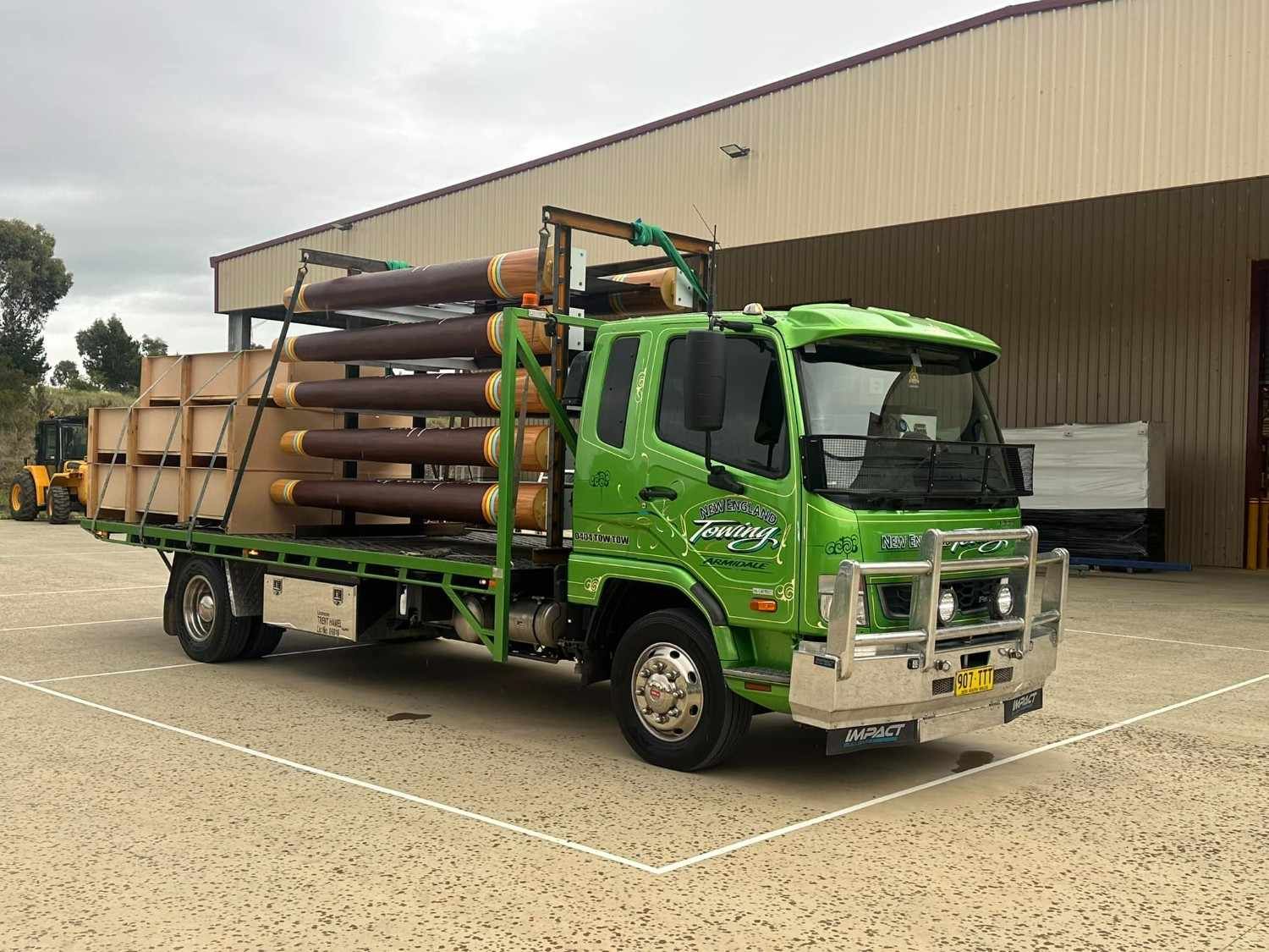 Green Delivery Truck Loaded with Pipes and Boxes — New England Towing in Inverell, NSW