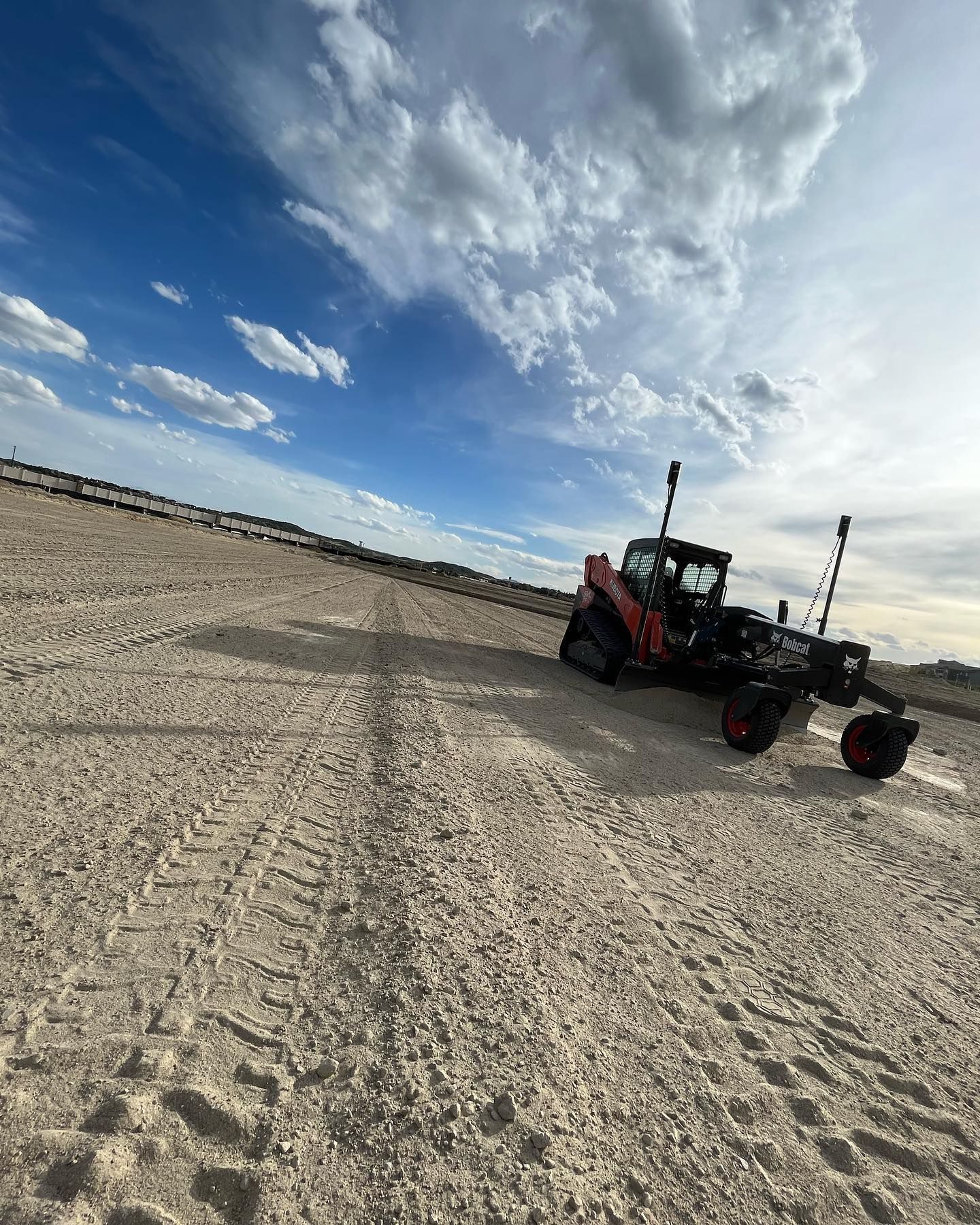 A tractor is parked in the middle of a dirt field.