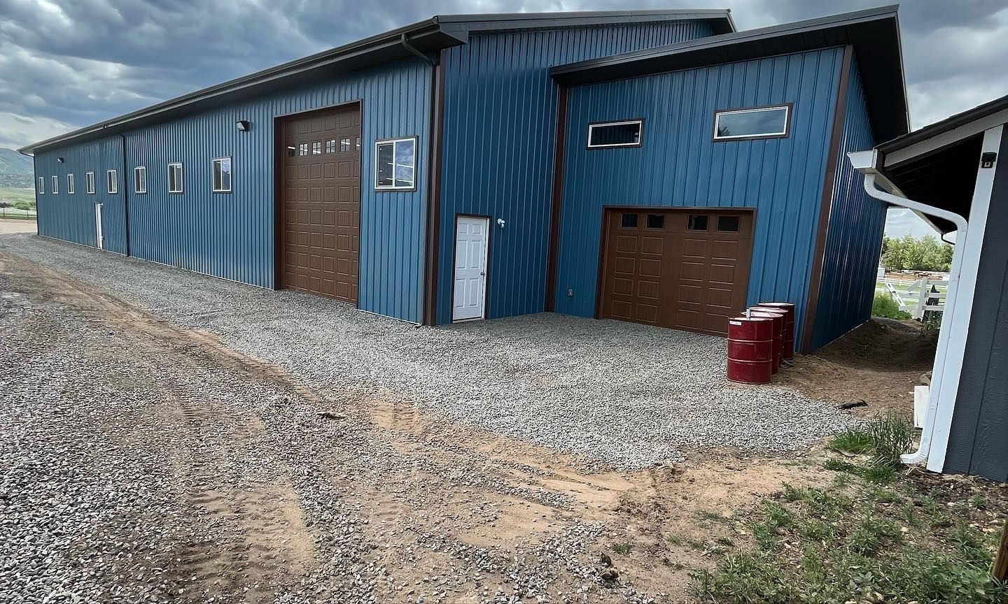 A blue building with a garage and a red cooler in front of it.