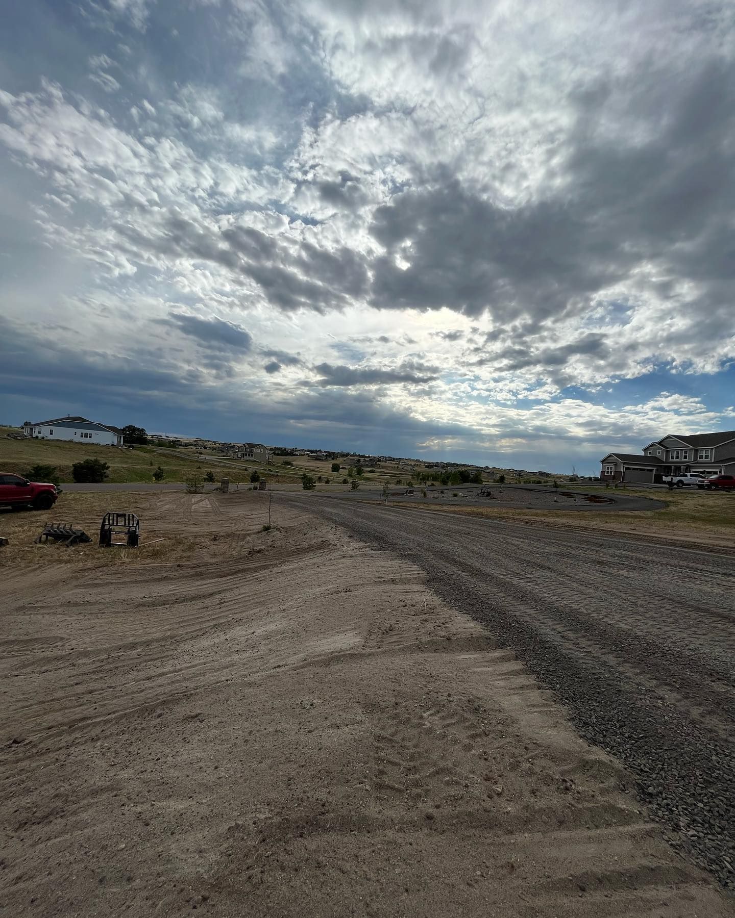 A dirt road with a cloudy sky in the background.