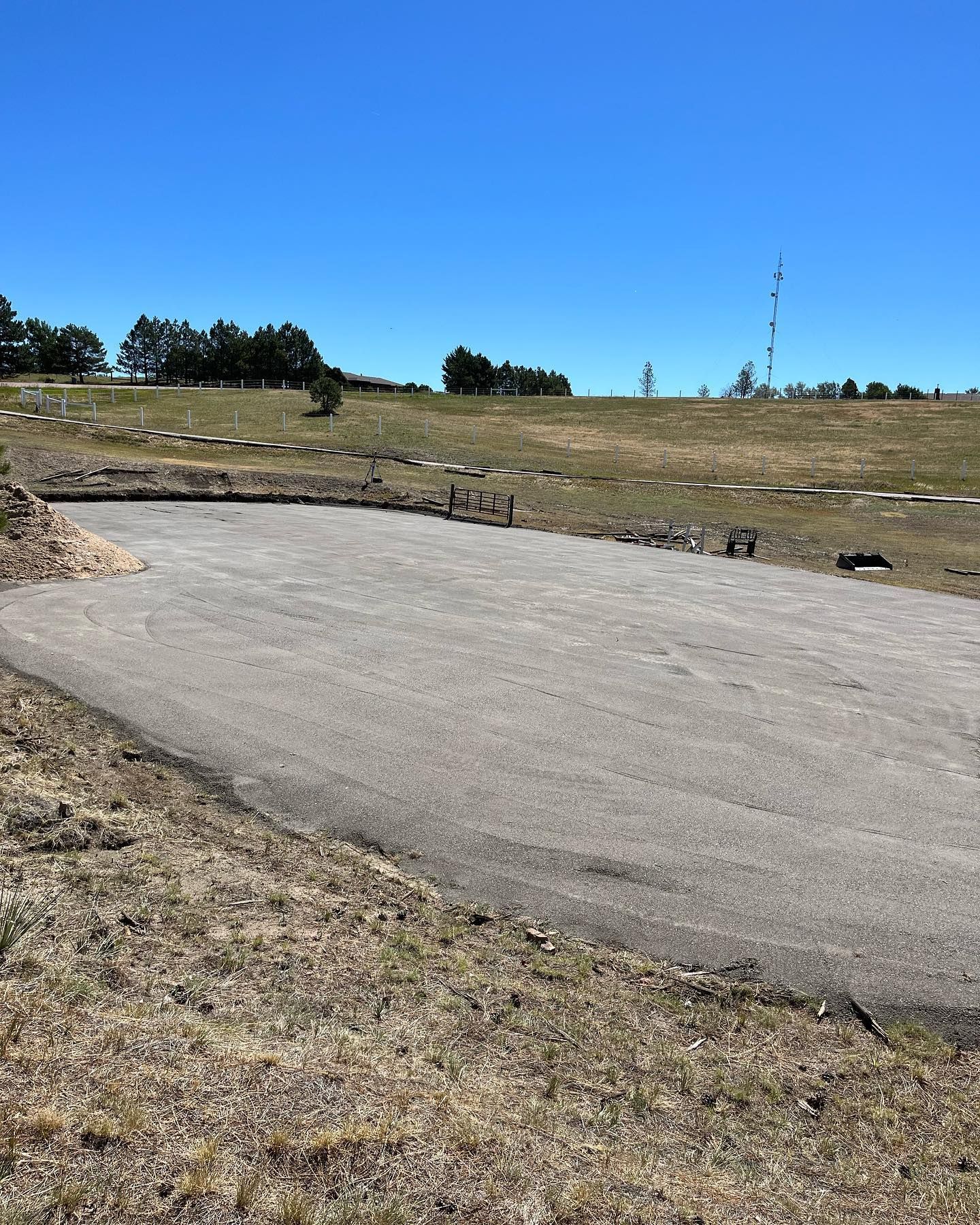 A road going through a grassy field on a sunny day