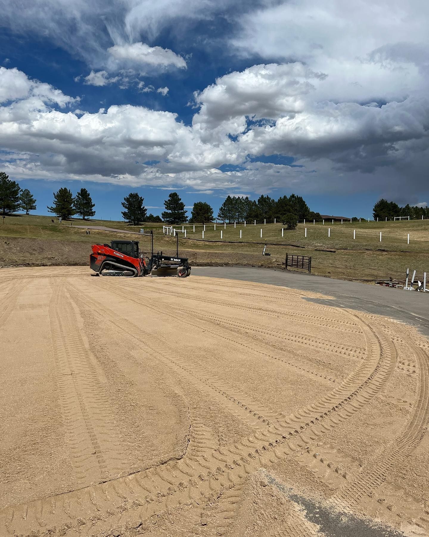 A red bulldozer is driving down a dirt road.