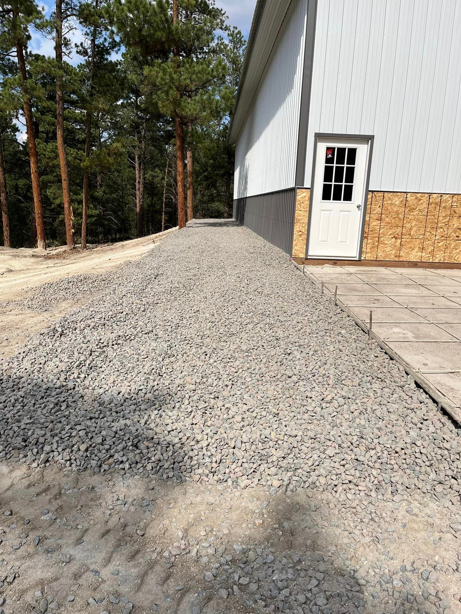 A pile of gravel is sitting in front of a building.