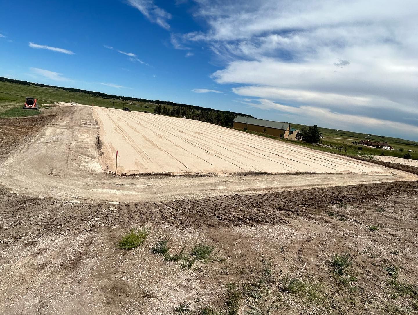 A large dirt field with a blue sky in the background