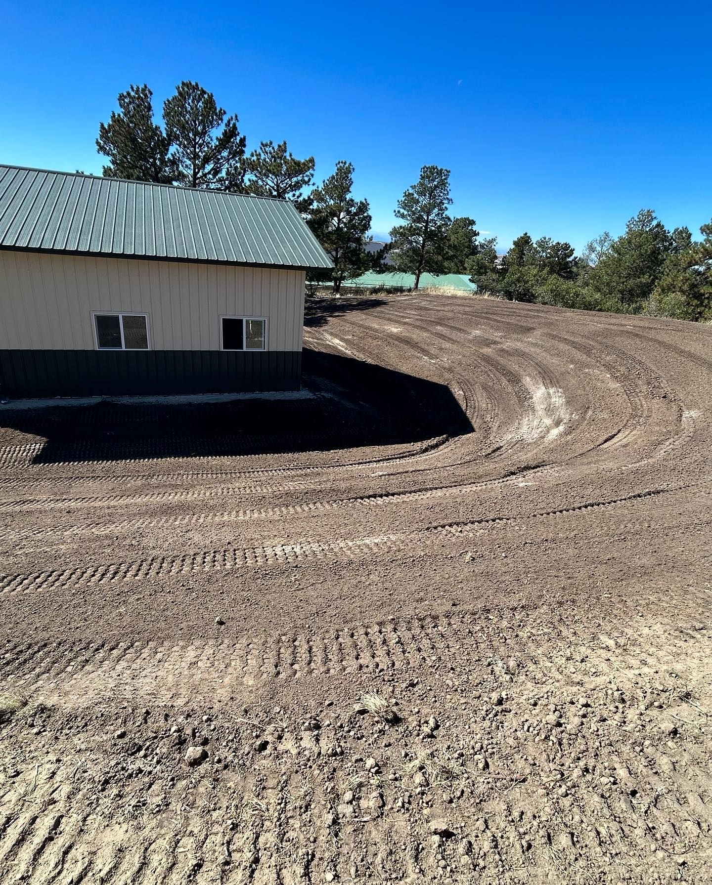 A house is sitting in the middle of a dirt field.