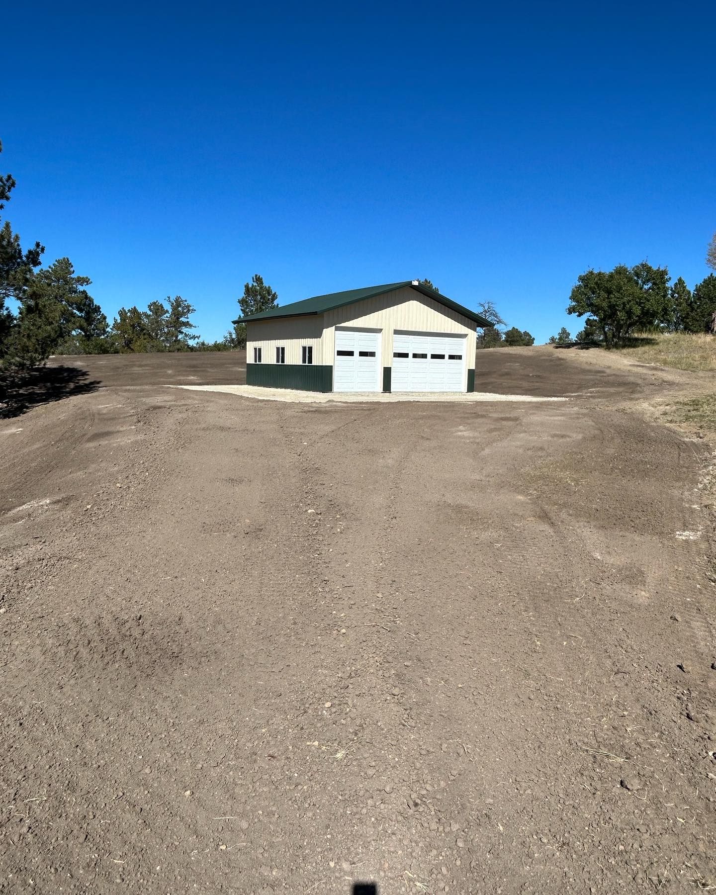 A house is sitting in the middle of a dirt road