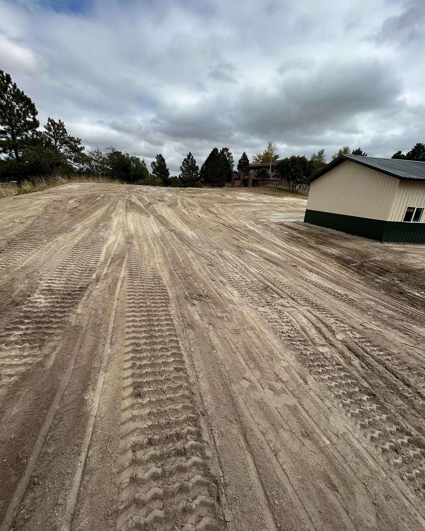 A dirt road with a house in the background.