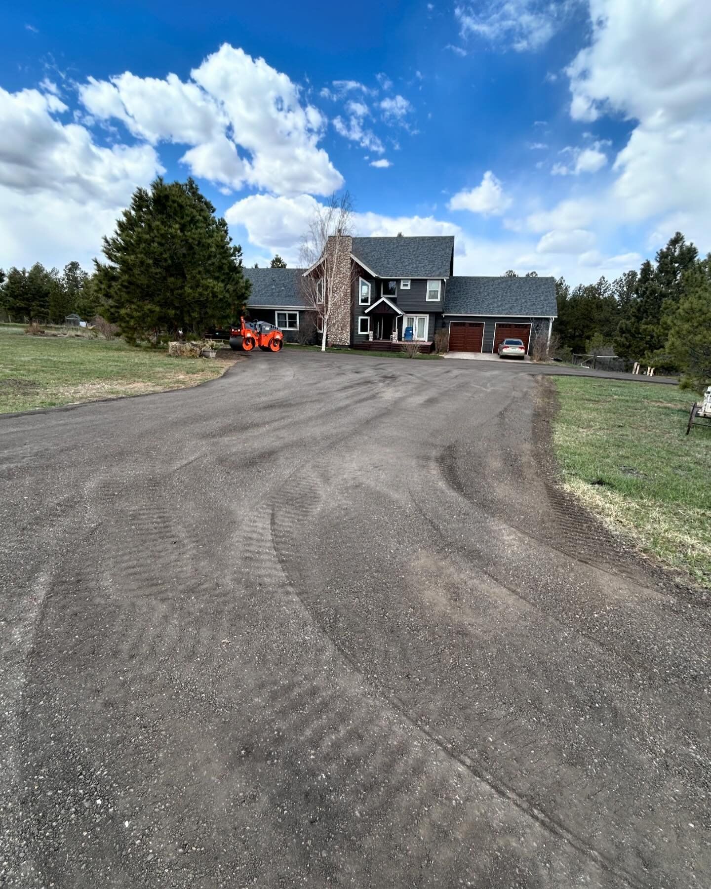 A large house is sitting in the middle of a dirt road.