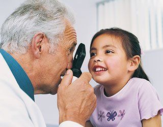 Well Visits — Doctor Examining Girl Eyes in Opelousas, LA