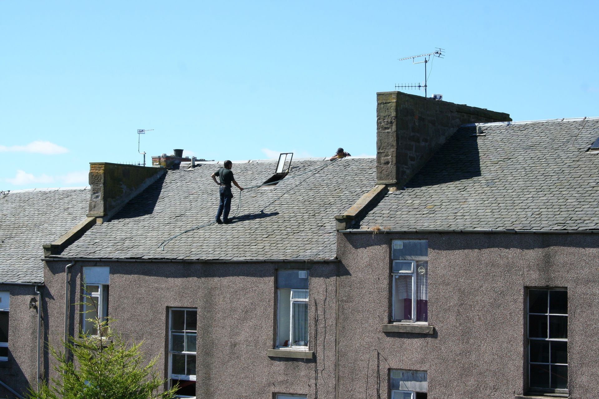 Three Multi-Unit Roofers from Commercial & Industrial Roofing Company, Inc., working on a slate roof on a house in La Presa, CA.