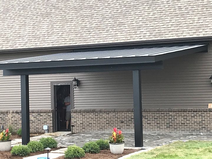 A house with a covered porch and a brick wall.