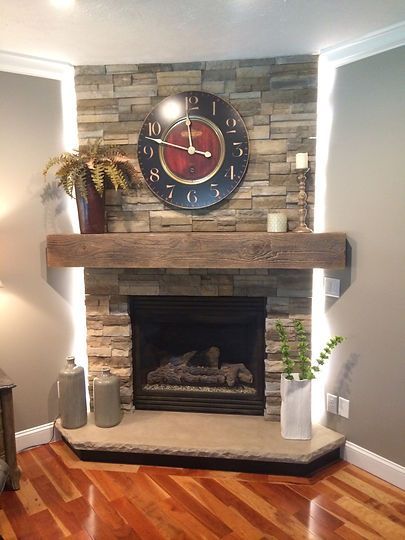 A living room with a fireplace and a clock on the wall.