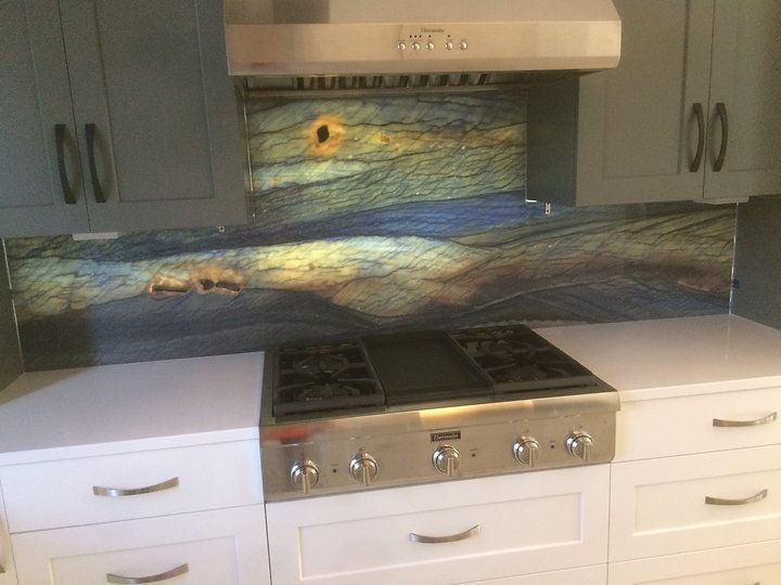 A kitchen with a stove top oven and a painting on the wall.