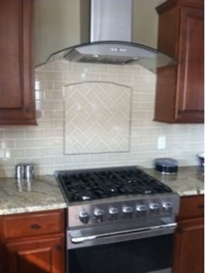 A kitchen with a stove and a hood above it