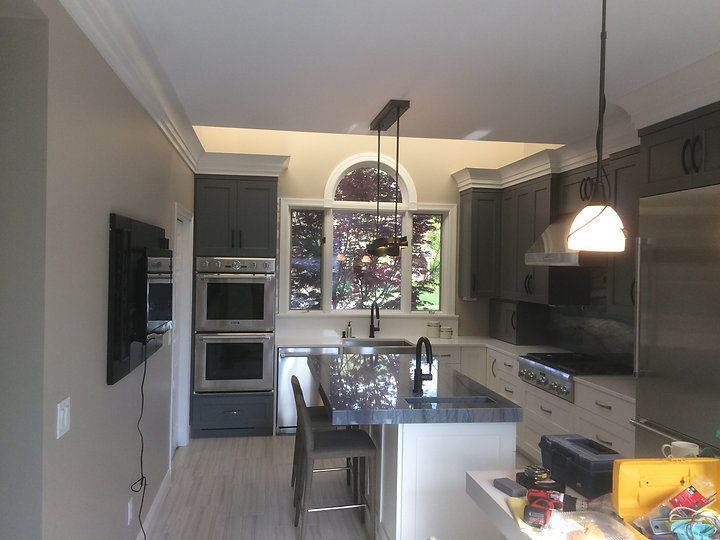 A kitchen with stainless steel appliances and gray cabinets