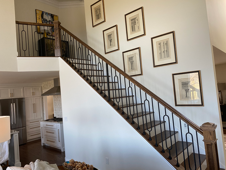 A staircase in a house with pictures on the wall.