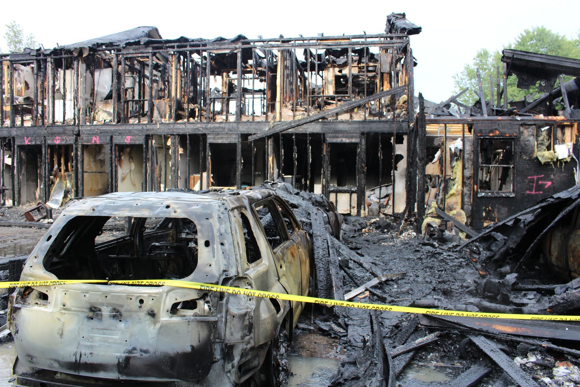 Two firefighters are standing in front of a large fire