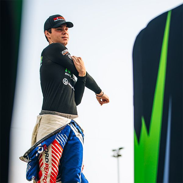 Max Opalski in a black shirt and blue pants is stretching his arms