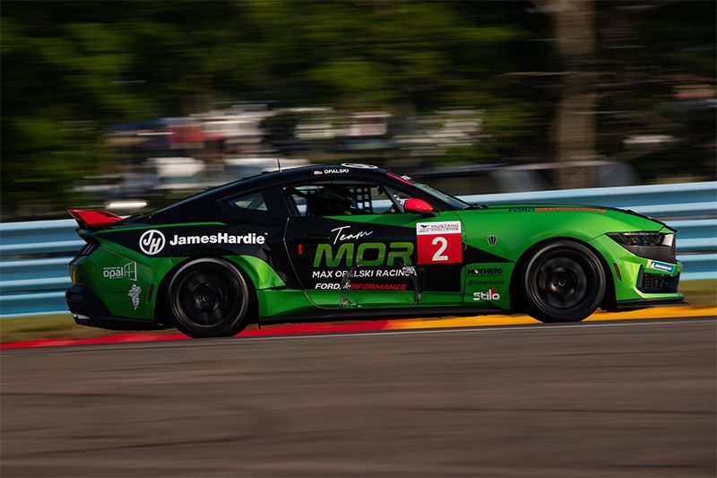 Max Opalski's green and black Darkhorse Mustang is driving on Watkins Glen Track.