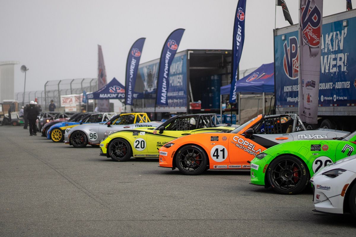 A row of race cars are parked next to each other on a track.
