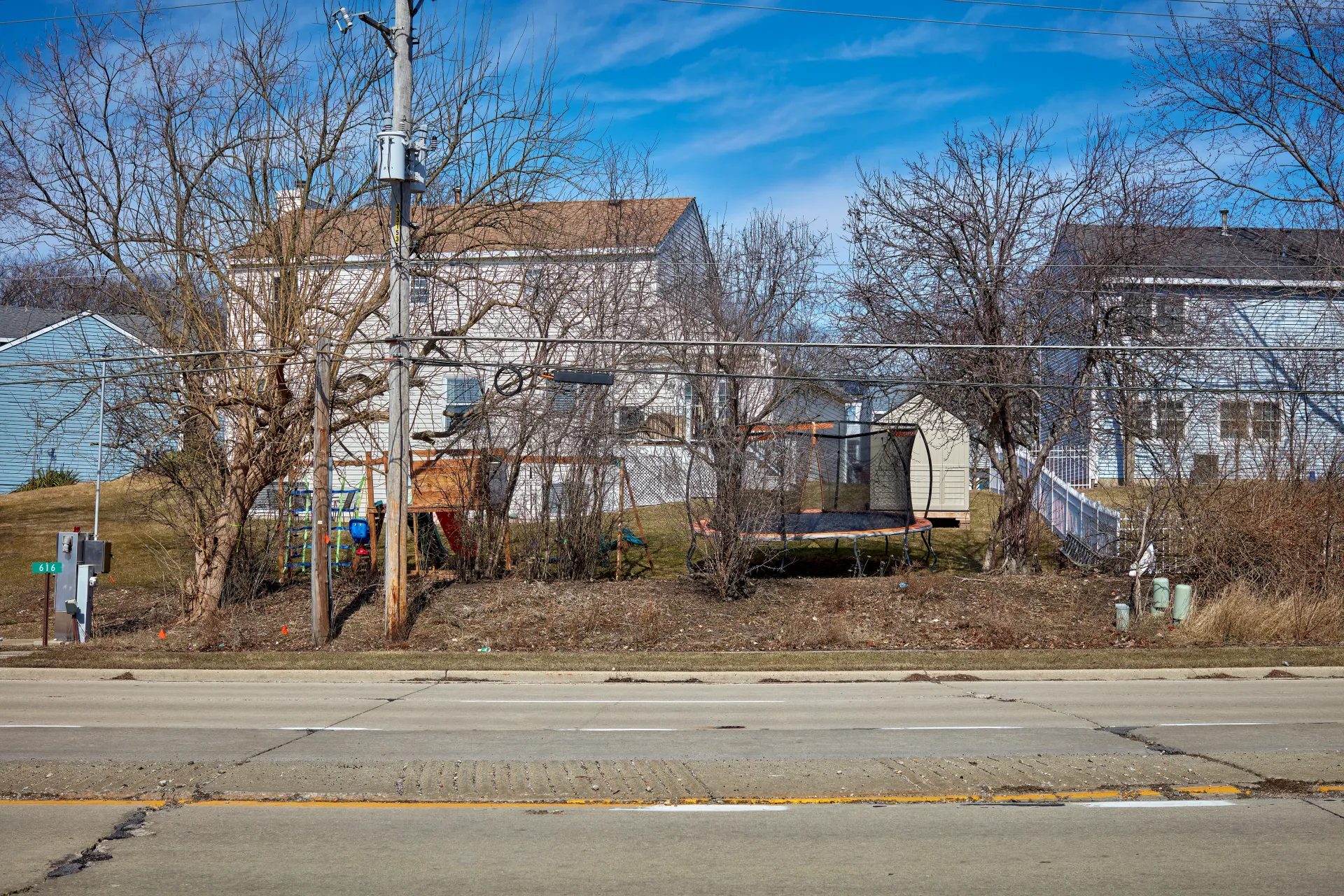 The jungle of American suburbs. The backyard can be used as a synonym for harmony, safety and relaxation. These suburban backyards represent the more contemporary meaning of this synonym and embody the lack of privacy, lack of safety and the inability to escape. Streamwood, Illinois 2023 - Robert Swiderski