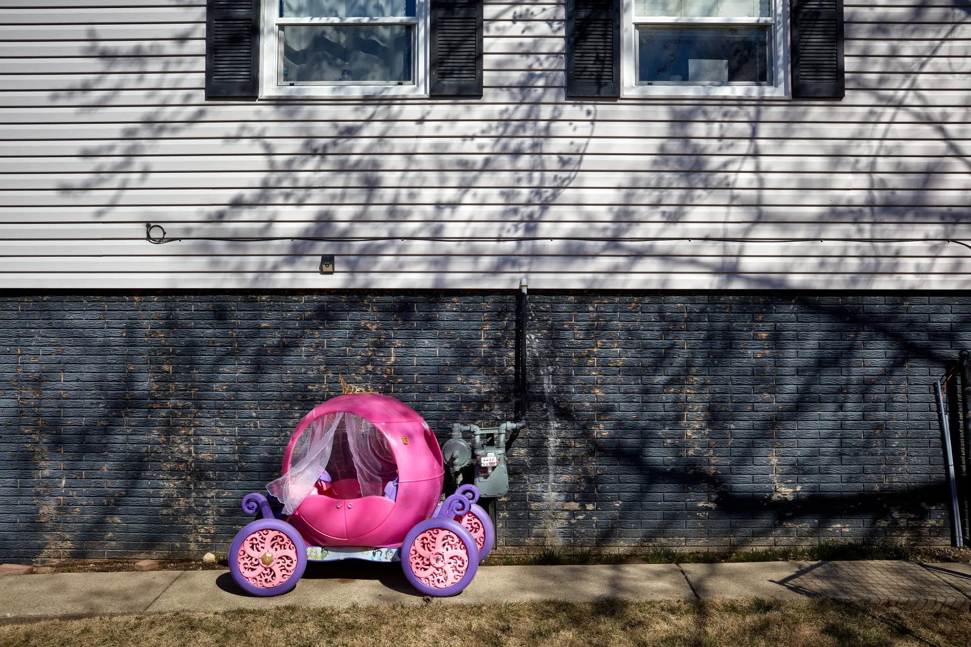 Pink Disney princes chariot. Yards littered with plastic toys - symbolic of the child focused culture in American suburbs, regardless of race, religion or affluence. Streamwood, Illinois 2023 - Robert Swiderski