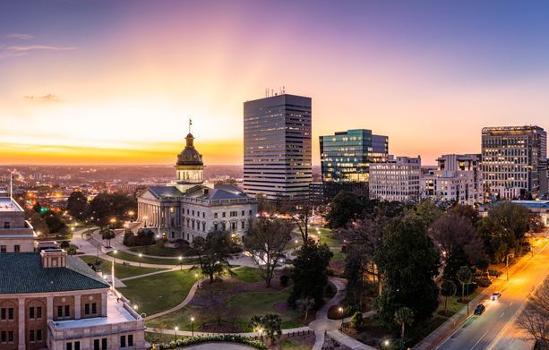 A man and a woman are sitting at a table reading a book.
