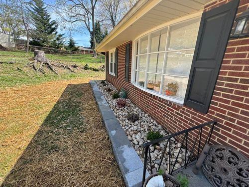 A Brick House With A Bench In Front Of It - Roanoke, VA - Duncan Design & Landscaping LLC