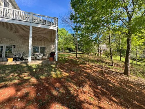 A Large White House With A Large Deck Is Surrounded By Trees And Dirt - Roanoke, VA - Duncan Design & Landscaping LLC