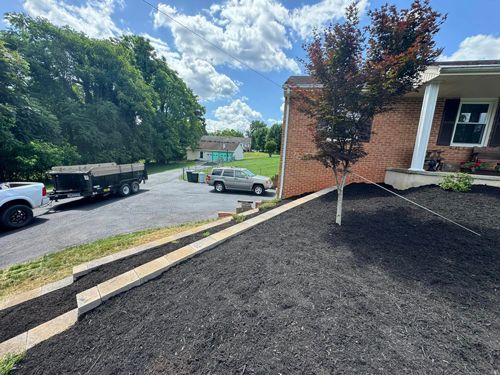 A White Truck Is Parked In Front Of A Brick House - Roanoke, VA - Duncan Design & Landscaping LLC