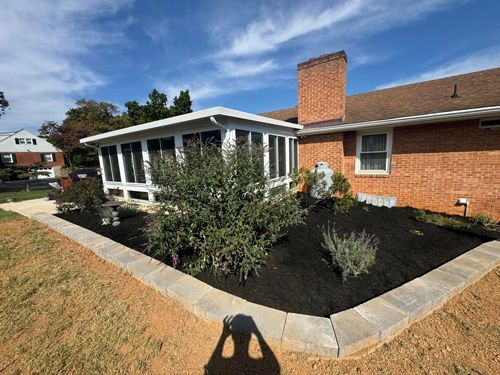 A Brick House With A Screened In Porch And A Garden In Front Of It - Roanoke, VA - Duncan Design & Landscaping LLC