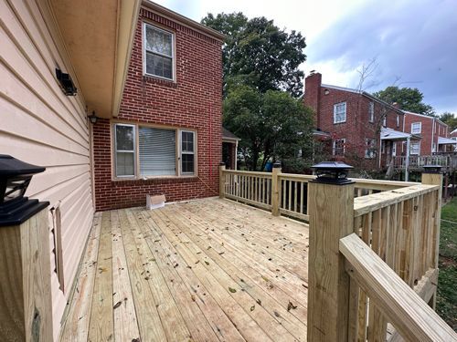 There Is A Wooden Deck In Front Of A Brick House - Roanoke, VA - Duncan Design & Landscaping LLC