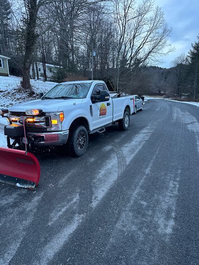 A White Truck With A Snow Plow Attached To It Is Parked On The Side Of A Road - Roanoke, VA - Duncan Design & Landscaping LLC
