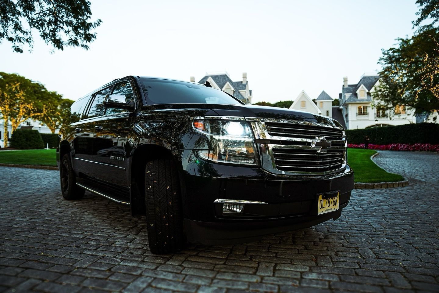 A man and a woman are standing next to a black car.
