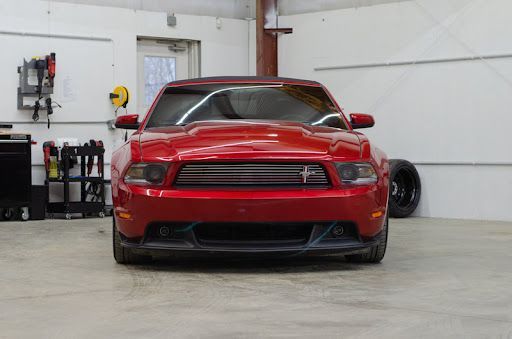 Red Ford Mustang in a garage.