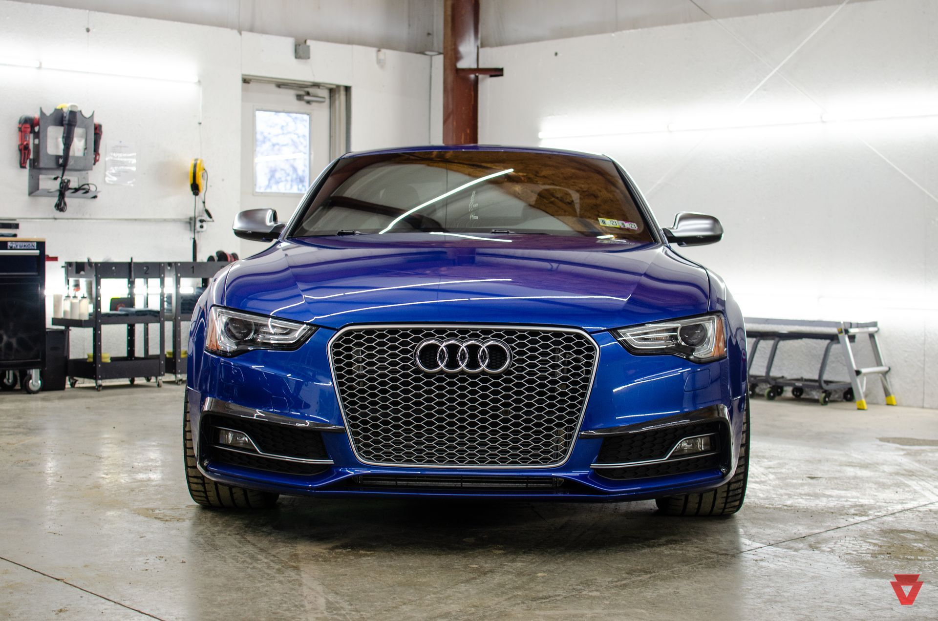 Blue Audi RS5 coupe in a garage.