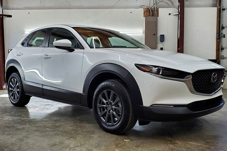 a white mazda cx-30 is parked in a garage .