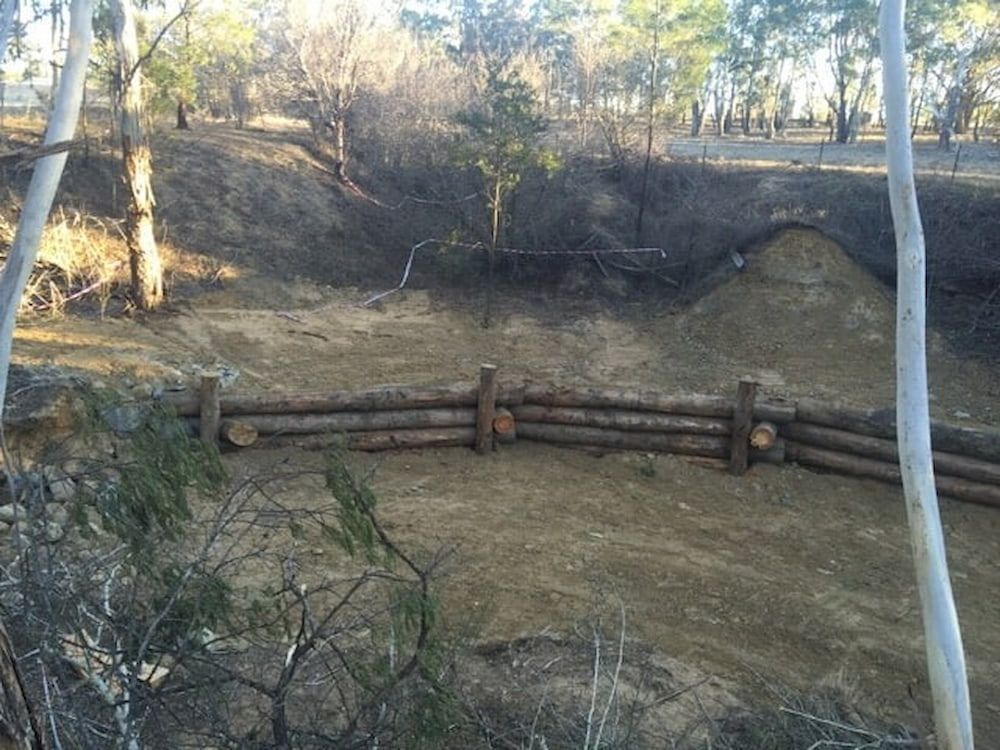 A grassy field with a wooden fence — Total Vegetation Management in Braemar, NSW